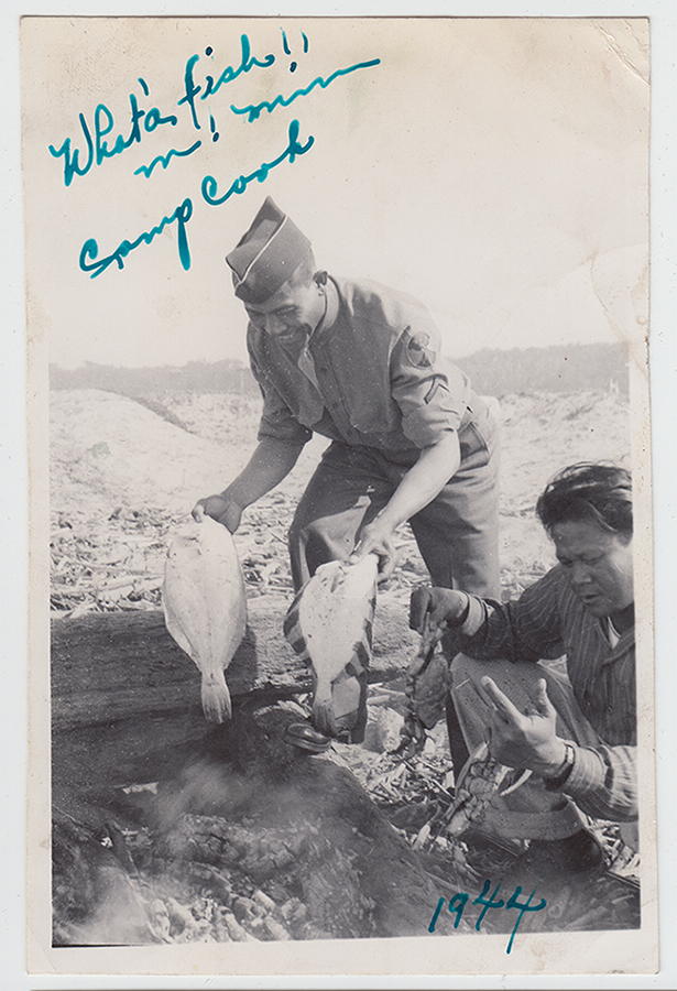 Two soliders fishing, one kneeling and the other half bent over, grinning, holding two fish